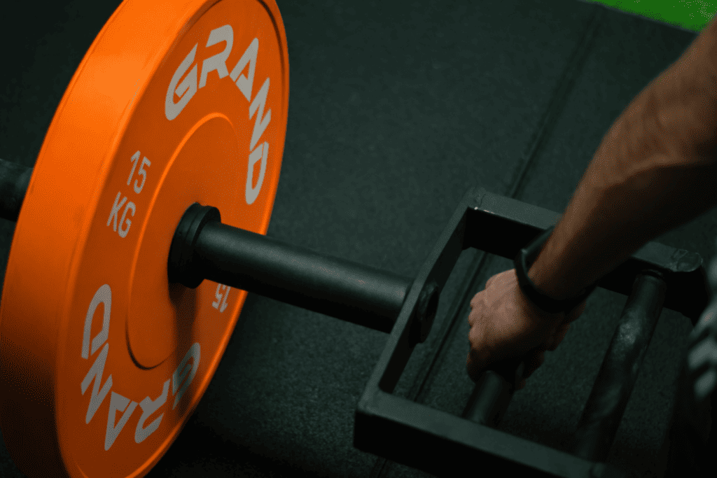 Ćwiczenie z użyciem sztangi trap bar z obciążeniem 15 kg. Siłownia.